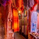 Vânzare de eșarfe și țesături colorate cu pigmenți naturali vii într-un souk din Medina din Marrakech