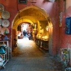 Străduță tipică din Medina din Marrakech, Maroc, cu souk-uri de produse artizanale și suveniruri locale