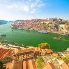 Vedere aerială a Podului Dom Luis I, a falezei Ribeira și a orizontului orașului Porto din Vila Nova de Gaia, Porto, Portugalia