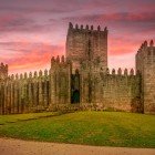 Priveliște la apus a Castelului din Guimarães, datând din epoca medievală și cunoscut și sub numele de São Mamede.