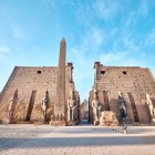 Intrarea principală a Templului din Luxor, cu accent pe primul pilon cu obelisc și statui ale lui Ramses II