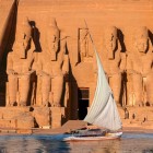 Scenografie spectaculoasă a fațadei Templului Abu Simbel văzută de pe o barcă cu vele navigând pe râul Nil