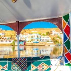 Sat nubian lângă Aswan văzut dintr-o ambarcațiune pe Nil; satele nubiene sunt caracterizate de case albe decorate cu picturi foarte vii